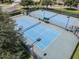 Aerial shot of a community's tennis courts that are surrounded by trees and green grass at 1427 Sw 161St St, Ocala, FL 34473