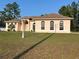Charming single-story home with arched windows, a well-manicured lawn, and mature trees at 15011 Sw 61St Court Rd, Ocala, FL 34473