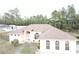 Aerial view of a light pink single-story home with an arched entry and a well-maintained roof at 15011 Sw 61St Court Rd, Ocala, FL 34473