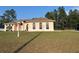 Charming single-story home featuring a manicured lawn and a peach exterior with arched windows at 15011 Sw 61St Court Rd, Ocala, FL 34473