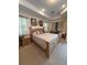 Spacious main bedroom featuring tray ceilings, neutral decor, and comfortable furnishings at 15011 Sw 61St Court Rd, Ocala, FL 34473