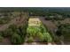 Scenic aerial view of vast land with scattered trees and a small dwelling, showcasing the property's tranquil seclusion at 15465 Se 113Th Street Rd, Ocklawaha, FL 32179