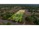 A wide aerial view showcases the property and its extensive acreage surrounded by trees at 15465 Se 113Th Street Rd, Ocklawaha, FL 32179