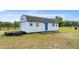 A light blue barn with a dark roof, accented by blue stars, with fencing in the back at 15465 Se 113Th Street Rd, Ocklawaha, FL 32179
