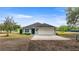 Charming single-story home featuring a clean gray exterior, well-maintained lawn and attached garage, creating welcoming curb appeal at 15465 Se 113Th Street Rd, Ocklawaha, FL 32179