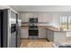 Updated kitchen showcasing stainless steel appliances, light-colored cabinets, and countertops with breakfast bar area at 15465 Se 113Th Street Rd, Ocklawaha, FL 32179