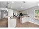 Open-concept kitchen with modern appliances, light cabinets, breakfast bar, and tile flooring at 15465 Se 113Th Street Rd, Ocklawaha, FL 32179