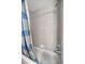 Shower with blue and grey tiled walls with silver fixtures and a shower curtain at 15465 Se 113Th Street Rd, Ocklawaha, FL 32179