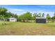 Landscape view featuring three small barns, a swing set, and green, grassy surroundings at 15465 Se 113Th Street Rd, Ocklawaha, FL 32179