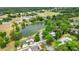 Aerial view of houses nestled amongst mature trees and a pond at 1617 Se 29Th Ter, Ocala, FL 34471