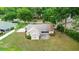 Aerial view showcasing the backyard of a home with a patio, lush lawn, and surrounded by mature trees at 1617 Se 29Th Ter, Ocala, FL 34471