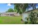 Backyard view featuring a home, shed, patio, and lush lawn, partially shaded by mature trees at 1617 Se 29Th Ter, Ocala, FL 34471