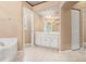 Neutral-toned bathroom with a vanity, large mirror, soaking tub, and separate toilet area at 1617 Se 29Th Ter, Ocala, FL 34471