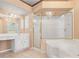 Bright bathroom featuring a vanity area, glass shower, and a large soaking tub for relaxation at 1617 Se 29Th Ter, Ocala, FL 34471