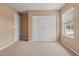 Neutral bedroom featuring plush carpet, natural light from a window, and a double door closet at 1617 Se 29Th Ter, Ocala, FL 34471