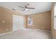 Bedroom featuring neutral carpet, a ceiling fan, a double door closet, and a window overlooking the yard at 1617 Se 29Th Ter, Ocala, FL 34471