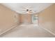 Large, carpeted bedroom with a ceiling fan, windows, and a sliding glass door leading to the outside at 1617 Se 29Th Ter, Ocala, FL 34471