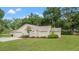 Home with a well-maintained lawn, attached garage, and complemented by a lush green backdrop of trees at 1617 Se 29Th Ter, Ocala, FL 34471