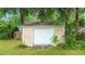 Backyard shed featuring a white door, and surrounded by mature trees at 1617 Se 29Th Ter, Ocala, FL 34471