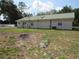 View of house with siding and green roof in backyard, also showing burned spot in grass at 1737 Griffin Ave, Lady Lake, FL 32159