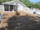 Large wooden deck with wicker chairs and outdoor area with lawn and pool at 1737 Griffin Ave, Lady Lake, FL 32159