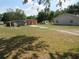 Exterior of homes and outbuildings on a grassy lot surrounded by trees at 1737 Griffin Ave, Lady Lake, FL 32159
