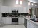 Well-equipped kitchen featuring stainless steel appliances, white cabinetry, and stylish backsplash at 1737 Griffin Ave, Lady Lake, FL 32159