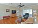 Inviting living area with hardwood floors, a comfortable recliner, a ceiling fan, and a screened-in lanai at 2550 Nw 55Th Avenue Rd, Ocala, FL 34482