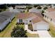 Aerial shot showcases this charming home with manicured landscaping and a convenient attached two-car garage at 2594 Berrington Loop, The Villages, FL 32162