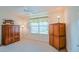 Bedroom with light-colored carpet, window, ceiling fan and wood furniture at 2594 Berrington Loop, The Villages, FL 32162
