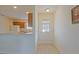 Inviting entryway with tiled floor, leading to a kitchen with white appliances and wooden cabinets at 2594 Berrington Loop, The Villages, FL 32162