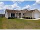 Inviting exterior with a lush lawn, sidewalk leading to the front door, and attached garage at 2594 Berrington Loop, The Villages, FL 32162