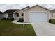 Charming home featuring an attached two-car garage, well-maintained lawn, and a welcoming front entrance at 2594 Berrington Loop, The Villages, FL 32162