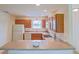 Efficient kitchen featuring wood cabinets, white appliances, and a breakfast bar for casual dining at 2594 Berrington Loop, The Villages, FL 32162