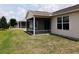 Exterior view of screened in back porches and an expanse of green grass in the backyard at 2594 Berrington Loop, The Villages, FL 32162
