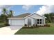 Charming single-story home with a two-car garage, light gray exterior, and a well-manicured front lawn at 2945 Ne 21St Terrace Rd, Ocala, FL 34470