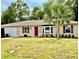 Charming home featuring a red door, red shutters, a bay window, and a well-manicured lawn at 3106 Silver Palm Dr, Edgewater, FL 32141