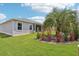 View of the backyard with a screened-in lanai and meticulously landscaped surroundings at 3500 Countryside Path, The Villages, FL 32163