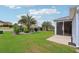 Well-maintained backyard with lush green grass, mature landscaping, and a screened lanai at 3500 Countryside Path, The Villages, FL 32163