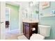 Bathroom with blue and green accents featuring vanity with dark wooden cabinets at 3500 Countryside Path, The Villages, FL 32163