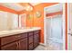 Bathroom with orange walls featuring a double vanity and a separate glass door shower at 3500 Countryside Path, The Villages, FL 32163