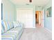 Bedroom with closet, neutral walls, and striped sofa for relaxing at 3500 Countryside Path, The Villages, FL 32163