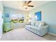 Bright bedroom with light blue walls, ceiling fan, and large window overlooking the neighborhood at 3500 Countryside Path, The Villages, FL 32163