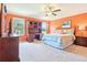 Spacious bedroom with orange walls, carpet, and views from the windows at 3500 Countryside Path, The Villages, FL 32163
