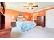 Bedroom with orange walls, carpet, ceiling fan, and matching wooden furniture at 3500 Countryside Path, The Villages, FL 32163