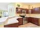 Kitchen with white countertops and stainless steel appliances and dark wood cabinets at 3500 Countryside Path, The Villages, FL 32163