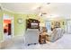 Comfortable living room featuring neutral carpet, a ceiling fan, and ample seating at 3500 Countryside Path, The Villages, FL 32163
