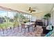 Inviting sunroom with stone floors, a dining table, and views of the landscaped backyard at 3500 Countryside Path, The Villages, FL 32163