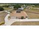 This aerial view presents the property's spacious backyard, detached garage, and screened patio at 4725 County Road 121D, Wildwood, FL 34785