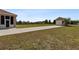 Expansive backyard with a driveway leading to a detached garage and partial view of the house at 4725 County Road 121D, Wildwood, FL 34785